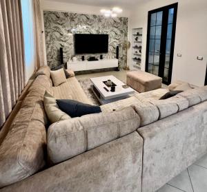 a large living room with a large couch at Villa Leandro in Fier