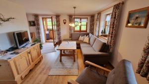 a living room with a couch and a tv at Ferienwohnung Milz in Obermaiselstein