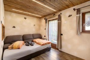 ein Schlafzimmer mit einem Sofa in einem Zimmer mit einem Fenster in der Unterkunft Sole tra le Cime - Trepalle in Livigno