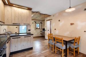 eine Küche mit einem Holztisch und Stühlen in der Unterkunft Sole tra le Cime - Trepalle in Livigno