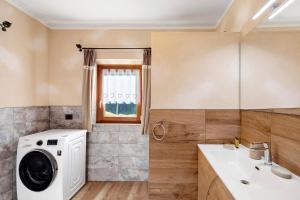 ein Badezimmer mit Waschmaschine und Waschbecken in der Unterkunft Sole tra le Cime - Trepalle in Livigno