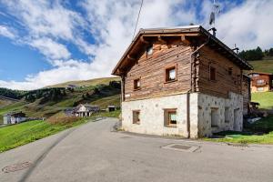 ein Holzgebäude am Straßenrand in der Unterkunft Sole tra le Cime - Trepalle in Livigno