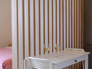 two glasses of wine on a table with two chairs at Pietra Sole Suites in Ierapetra