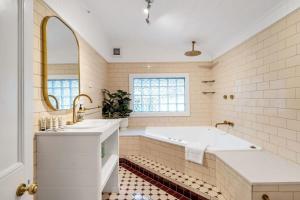 a white bathroom with a tub and a sink at Loch Lomond Home Mountain Retreat Katoomba in Katoomba +36 photos