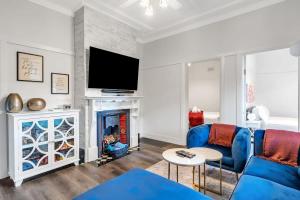 a living room with a blue couch and a fireplace at Loch Lomond Home Mountain Retreat Katoomba in Katoomba