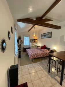 a bedroom with a bed and a table in a room at L'Opaline in Tully
