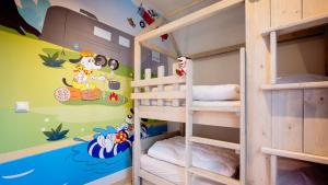 ein Etagenbettzimmer mit zwei Etagenbetten und einem Wandgemälde in der Unterkunft Bungalows Papillon Country Resort in Denekamp