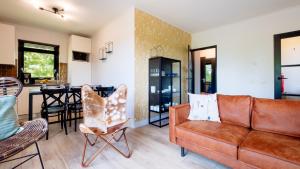 ein Wohnzimmer mit Sofa, Stühlen und einem Tisch in der Unterkunft Bungalows Papillon Country Resort in Denekamp + 7 Fotos