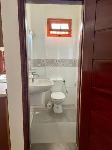 a bathroom with a toilet and a sink at Lindsey House in Saint-Louis +13 photos
