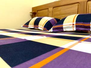 a bed with colorful pillows on it at Luxury apartment Yaoundé in Mimboman