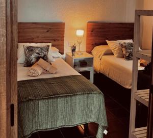 a hotel room with two beds and a night stand at Finca Dos Vientos Tarifa in Tarifa +27 photos