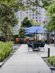 a patio with tables and umbrellas in a park at Star KLCC Twin Tower Cozy 2-3pax by DingDing in Kuala Lumpur