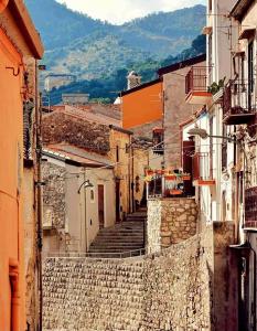 an alley with stairs in a town with mountains at Suite Borgo 74 in Piana degli Albanesi +32 photos