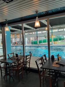 a restaurant with a swimming pool and tables and chairs at Blekkerke 57 in Koksijde