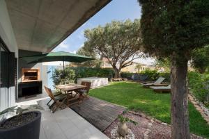 podwórko z drewnianym tarasem ze stołem i parasolem w obiekcie Villa Sea-Esta by An Island Apart w mieście Porto Santo
