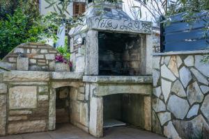 - une cheminée extérieure en pierre dans une cour en pierre dans l'établissement Villa Laura Krnica near Pula for 8 people - pet friendly with children playground, à Krnica