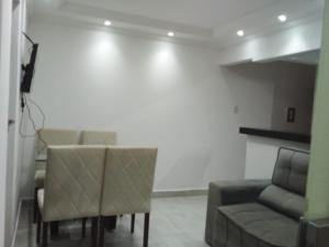 a living room with a couch and a table and chairs at Apto 2 quartos Nucleo Bandeirante in Brasília