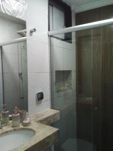 a bathroom with a sink and a glass shower at Apto 2 quartos Nucleo Bandeirante in Brasilia