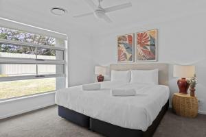 a white bedroom with a large bed and two windows at Wine Down 700m walk to Cessnock CBD in Cessnock +32 photos
