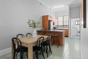 a kitchen and dining room with a wooden table and chairs at Haven on Hunter 500m to Civic Theatre in Newcastle