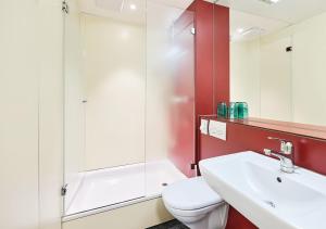 un bagno con wc, lavandino e doccia di Hotel Pickwick and Pub "the room with a view" a Lucerna