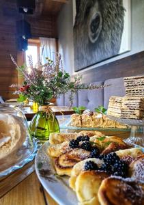 a table topped with plates of pastries on a table at Niedźwiedzia Residence Garden & Sauna in Poronin +76 photos