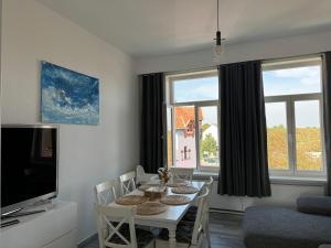 GehrdenにあるModerne 4 Zimmer Apartment mit Bergblick Stadtzentrum Contactless Check-inのダイニングルーム(テーブル、椅子、テレビ付)