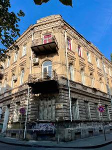 ein altes Gebäude am Straßenrand in der Unterkunft Communa Good Vibes in Tbilisi City