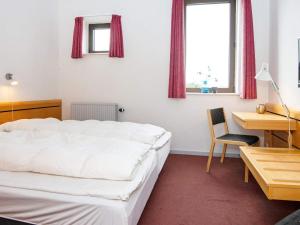 a bedroom with a bed and a desk and a chair at Apartment in Holiday Park in Vederso Klit in Ulfborg +32 photos