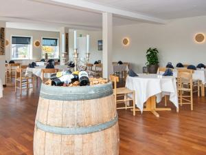 a restaurant with tables and chairs and a barrel at Apartment in Holiday Park in Vederso Klit in Ulfborg