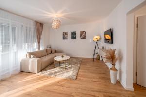 a living room with a couch and a table at Traumhaftes Apartment -Balkon -Hängesessel -WiFi in Viersen