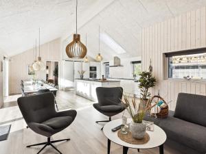 a living room with chairs and a table and a kitchen at Luxury Retreat in Romo - By Traum Ferienwohnungen in Kongsmark