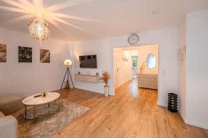 a living room with a table and a clock on the wall at Traumhaftes Apartment -Balkon -Hängesessel -WiFi in Viersen