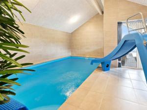 a indoor swimming pool with a slide in a house at Luxury Retreat in Romo - By Traum Ferienwohnungen in Kongsmark