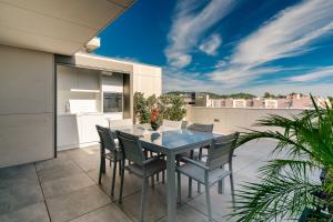 a dining room table and chairs on a balcony at River Town View - Luxury Apartment with Jacuzzi on Terrace in Viana do Castelo