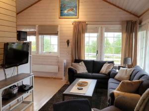 Una sala de estar con un sofá y un televisor. en 6 person holiday home in Rebbenes, en Rebbenes