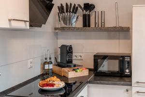 a kitchen with a microwave and a plate of food on a counter at Traumhaftes Apartment -Balkon -Hängesessel -WiFi in Viersen