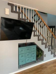 a living room with a flat screen tv and a staircase at Charming 3 bed 3 bath home, super cozy, close to DIA in Altura +7 photos