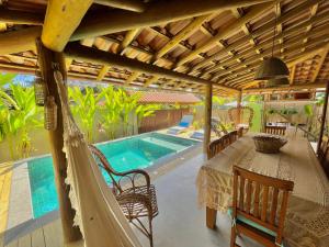 a patio with a table and chairs and a swimming pool at Villa Milagre in Trancoso