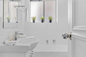baño blanco con lavabo y 2 ventanas en Parklea Sun Seabreeze The Entrance Sleeps 5, en The Entrance 23 fotos más