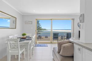 Una cocina y una sala de estar con mesa y sillas. en Parklea Sun Seabreeze The Entrance Sleeps 5, en The Entrance