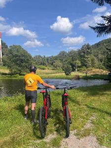 a man standing next to two bikes next to a river at gite du Breuchin 2 in La Longine +2 photos