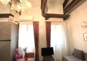 a living room with white curtains and a television at Cà Baratti in Venice