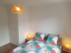 a bedroom with a bed with a colorful comforter at Le Julianais in Saint-Julien