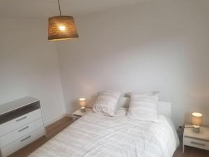 a bedroom with a bed with two lamps and a dresser at Le Julianais in Saint-Julien