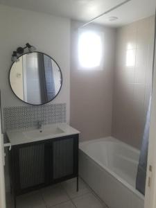 a bathroom with a sink and a mirror and a tub at Le Julianais in Saint-Julien