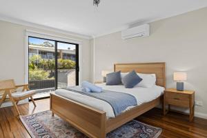 una camera da letto con un letto e una grande finestra di Lakeview Oasis on The Esplanade a Warners Bay