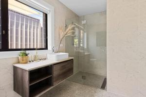 un bagno con lavandino e doccia in vetro di Lakeview Oasis on The Esplanade a Warners Bay Altre 37 foto