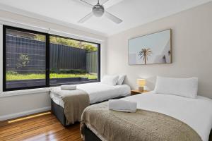 due letti in una stanza con finestra di Lakeview Oasis on The Esplanade a Warners Bay