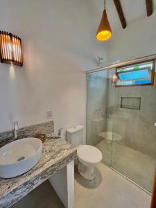 a bathroom with a sink and a toilet and a shower at Villa Milagre in Trancoso